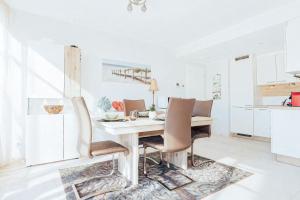 a white kitchen with a wooden table and chairs at Stunning 2 bed Mamer free parking in Mamer