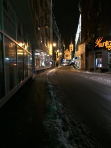an empty city street at night with snow on the ground at Apartment Bujrum & Enjoy in Sarajevo