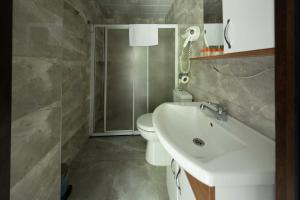 a bathroom with a white sink and a toilet at Elikti Otel in Ardeşen