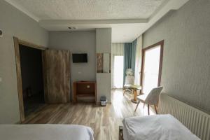 a room with two beds and a table and a window at Elikti Otel in Ardeşen