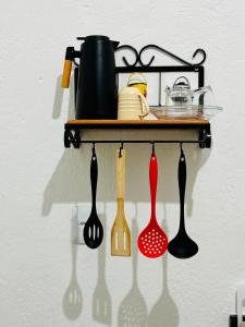 a rack with cooking utensils hanging on a wall at Voer Jequitibá Hospedaria in Jequitibá