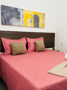 a bedroom with a pink bed with two pillows at Voer Jequitibá Hospedaria in Jequitibá