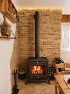 a stove in a living room with a brick wall at Le Terrier- Chaleureux avec Jardin privatif et parking pour 2 voitures in Briançon +54 photos