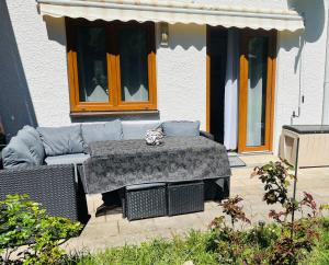 a patio with a couch and a table in front of a building at Christines Ferienwohnung in Weiler-Simmerberg