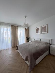 a white bedroom with a large bed and windows at Dobre Miejsce in Skoczów