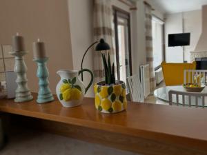 two vases sitting on top of a wooden table at Lemon & Light Bright Apartment with View and Fireplace in Meligalás