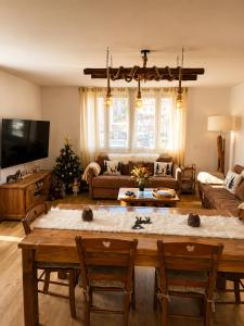 a living room with a table and a christmas tree at Le Terrier- Chaleureux avec Jardin privatif et parking pour 2 voitures in Briançon