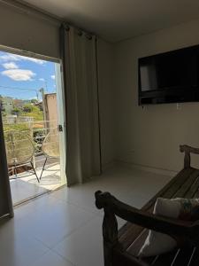 a bedroom with a bed and a sliding glass door at Apartamento do Sol in Diamantina