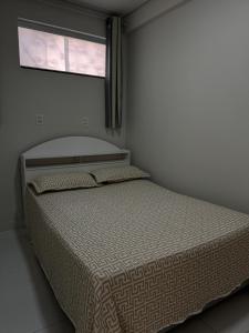 a bed in a bedroom with a window at Apartamento do Sol in Diamantina +4 photos