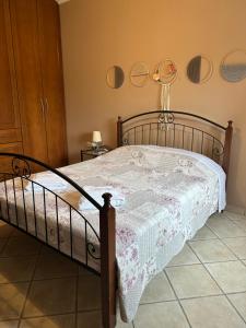 a bedroom with a wooden bed with a white blanket at Lemon & Light Bright Apartment with View and Fireplace in Meligalás