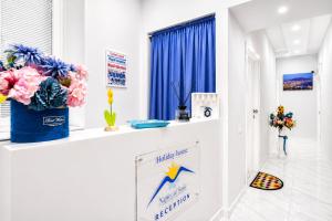a white room with blue curtains and flowers on a counter at Neve Al Sole Modern Suites near Metro Materdei in Naples Center in Naples