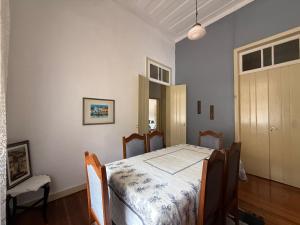 a bedroom with a bed with a table and chairs at Casarão Cidade Imperial in Petrópolis