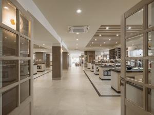 a large kitchen with white counters and a cafeteria at Sirios Village Hotel & Bungalows - All Inclusive in Kato Daratso