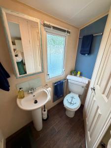 a bathroom with a sink and a toilet and a window at The Conwy Escape in Conwy +21 photos