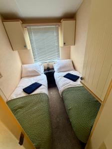 two beds in a small room with a window at The Conwy Escape in Conwy