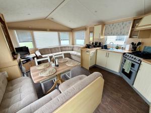 a kitchen and a living room with a table in a caravan at The Conwy Escape in Conwy