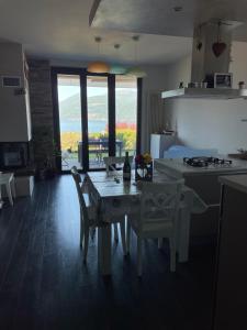 a kitchen with a table and chairs and a kitchen with a view at My sweet balcony in Germignaga
