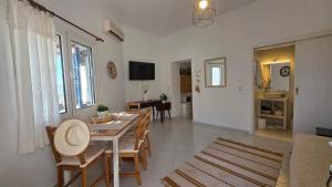a living room with a dining room table and chairs at Spitaki Milos in Tripiti