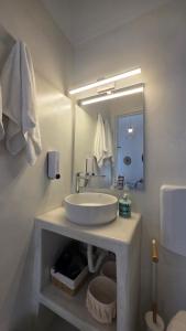 a white bathroom with a sink and a mirror at Spitaki Milos in Tripiti +23 photos