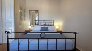a bed in a bedroom with two lamps and a mirror at Spitaki Milos in Tripiti