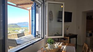 a dining room with a table and a large window at Spitaki Milos in Tripiti