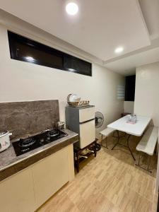 a kitchen with a stove and a table in it at Arceo Homestay 2 Bedroom unit in Puerto Princesa City