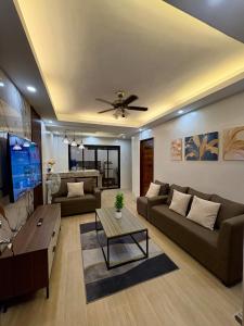 a living room with two couches and a tv at Arceo Homestay 2 Bedroom unit in Puerto Princesa City