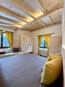a large bed in a room with wooden ceilings at Chalet il pino in San Bernardo
