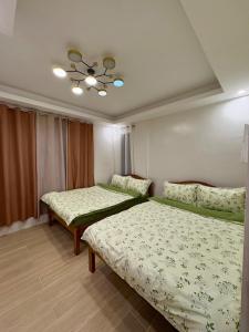 a bedroom with two beds and a ceiling at Arceo Homestay 2 Bedroom unit in Puerto Princesa City