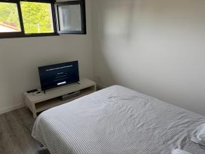 a bedroom with a bed and a flat screen tv at Chambre spacieuse #3 in Clonas-sur-Varèze