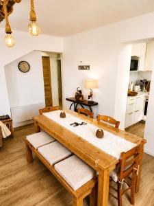 a dining room with a wooden table and chairs at Le Terrier- Chaleureux avec Jardin privatif et parking pour 2 voitures in Briançon