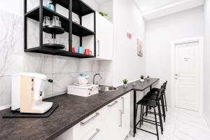 a kitchen with a counter with stools in it at Neve Al Sole Modern Suites near Metro Materdei in Naples Center in Naples
