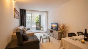 a living room with a couch and a television at Appartamento Residence Mimose - con parcheggio e Terrazza vicino al mare in Eraclea Mare