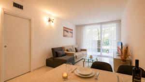 a living room with a table and a couch at Appartamento Residence Mimose - con parcheggio e Terrazza vicino al mare in Eraclea Mare