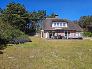 a house with lounge chairs on a lawn at Fazant (12p) in Buren
