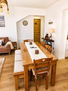 a dining room with a wooden table and chairs at Le Terrier- Chaleureux avec Jardin privatif et parking pour 2 voitures in Briançon