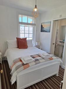a white bed in a room with a window at The Studio Apartment in Weymouth