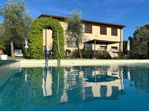 a villa with a swimming pool in front of a house at Agriturismo IL VIAIO in Fiesole