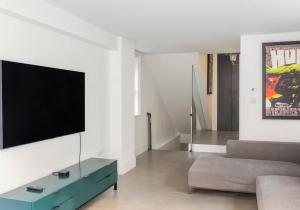 a living room with a flat screen tv and a couch at 3 Bedroom, 3 bathroom large flat with sea views! in Hastings