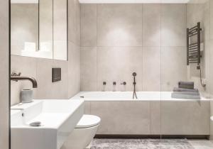 a bathroom with a tub and a toilet and a sink at 3 Bedroom, 3 bathroom large flat with sea views! in Hastings +29 photos