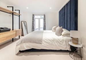 a bedroom with a large bed with a blue headboard at 3 Bedroom, 3 bathroom large flat with sea views! in Hastings