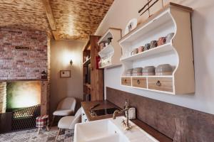 a kitchen with a sink and a counter with shelves at La Baguette du Sorcier - Logement insolite immersif jusque 4 personnes entre Liège & Maastricht in Visé