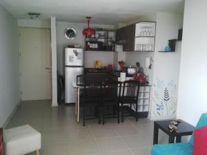 a kitchen and dining room with a table and a refrigerator at Algarrobo Norte Apartmento in Algarrobo