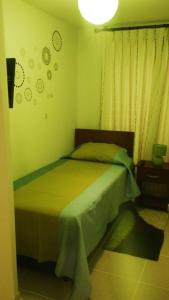 1 dormitorio con 1 cama en una habitación con paredes verdes en Algarrobo Norte Apartmento, en Algarrobo