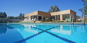a large swimming pool in front of a house at Algarrobo Norte Apartmento in Algarrobo