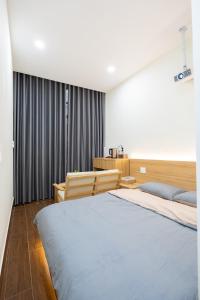 a bedroom with a large bed and two chairs at Cái Vườn Ấm in Lái Thiêu