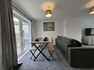 a living room with a couch and a table at Spacious 3 Bedroom House with Large Drive in Dundee