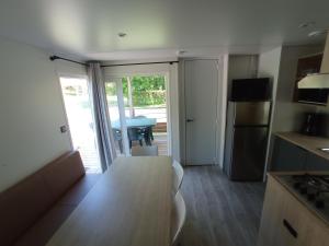 a kitchen with a table and a kitchen with a door to a patio at Camping La Bâtisse in Réalmont +15 photos