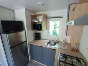 a small kitchen with a sink and a refrigerator at Camping La Bâtisse in Réalmont