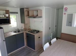a small kitchen with a sink and a stove at Camping La Bâtisse in Réalmont